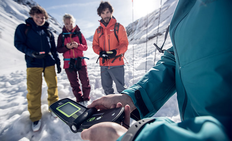 Met de lawine-nooduitrusting moet elke toerskiër zich bezighouden – ook als beginner, voordat hij voor de eerste keer van de piste het terrein in gaat. Close-up van een lawinepieper in de hand van een toerskiër.
