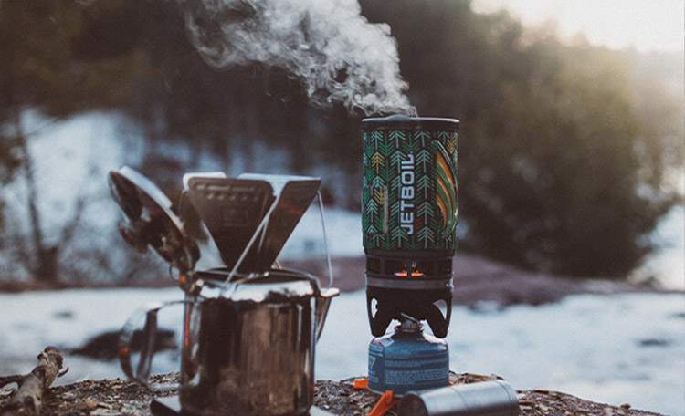 Thee gezet en je bent klaar om de kou te trotseren! Close-up van een gasbrander in een winterlandschap.